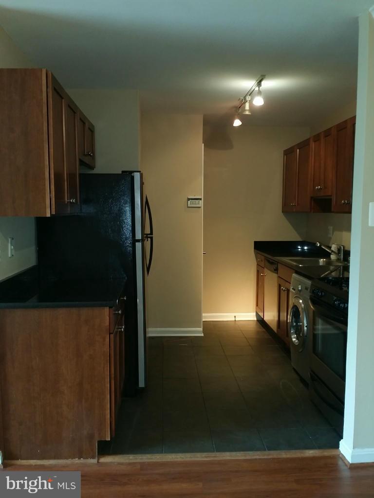 3105 Naylor Road Southeast, Unit 303 Washington, DC 20020 - Photo 4 of 10 a kitchen with stainless steel appliances wooden cabinets and a refrigerator