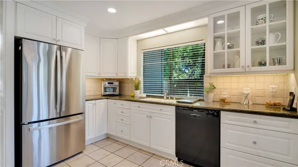 a kitchen with stainless steel appliances granite countertop a refrigerator and a sink