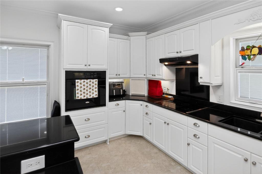 4113 Ledan Extension Gainesville, GA 30506 - Photo 73 of 195 a kitchen with granite countertop white cabinets and black appliances