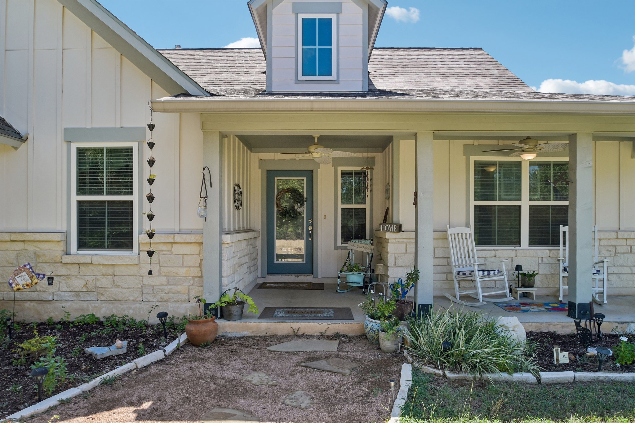 596 Pleasant Grove Loop Elgin, TX 78621 - Photo 2 of 37 A welcoming front porch features classic stone wainscoting and a cozy covered entryway.