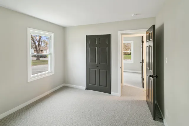 an empty room with windows and closet