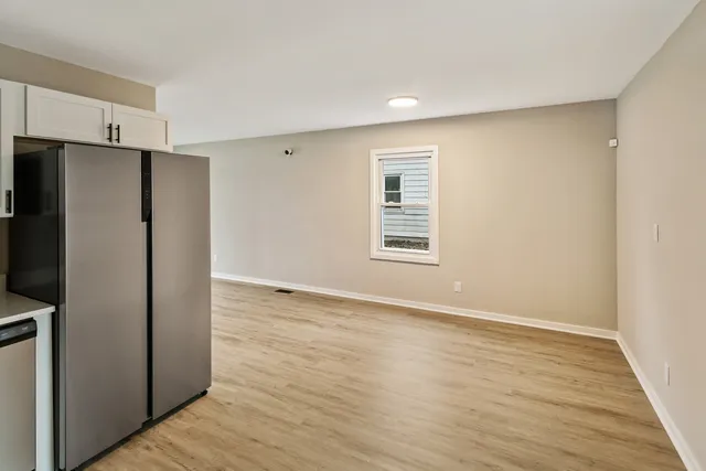 a view of an empty room with a kitchen