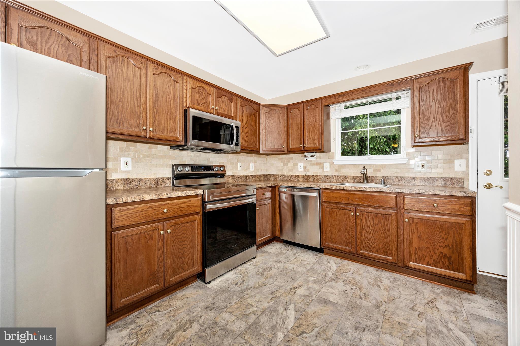 1007 Parade Lane Mount Airy, MD 21771 - Photo 19 of 55 a kitchen with granite countertop a refrigerator stove top oven a sink and dishwasher