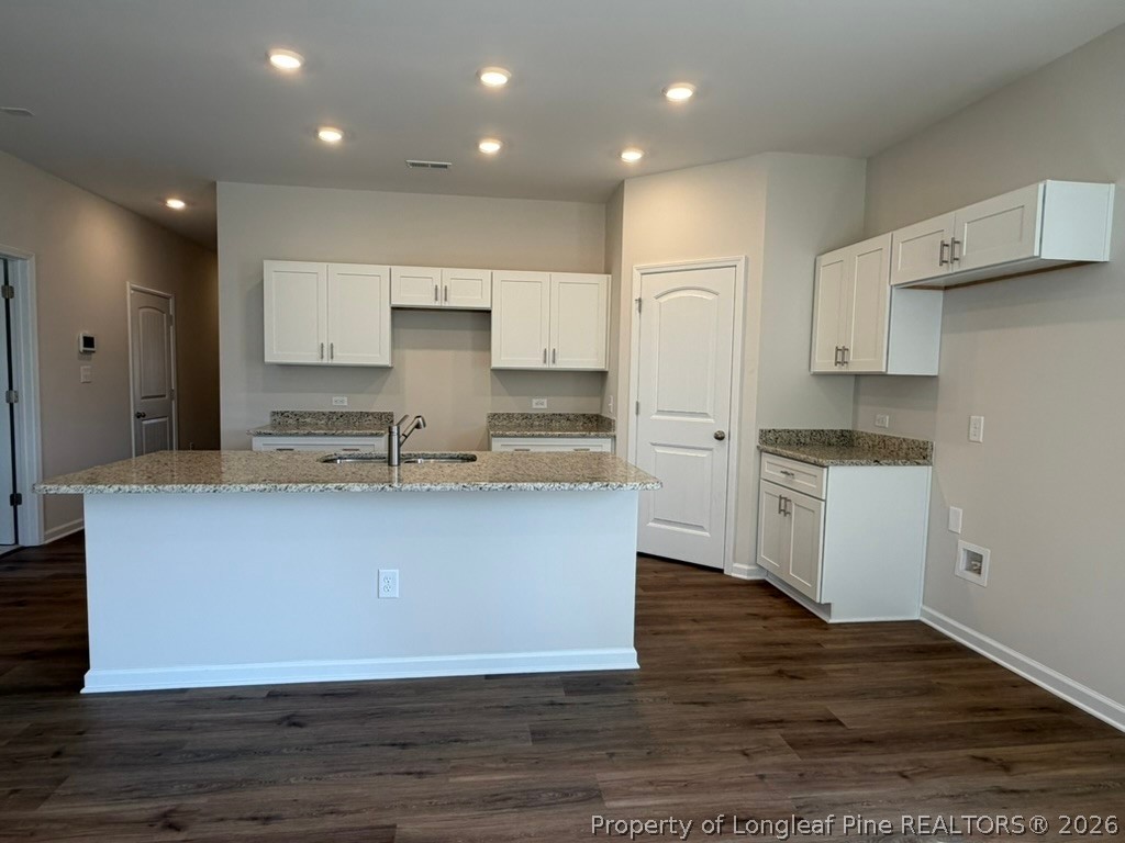 5409 Short Leaf Road Fayetteville, NC 28311 - Photo 16 of 40 a large kitchen with stainless steel appliances granite countertop a stove a sink and white cabinets