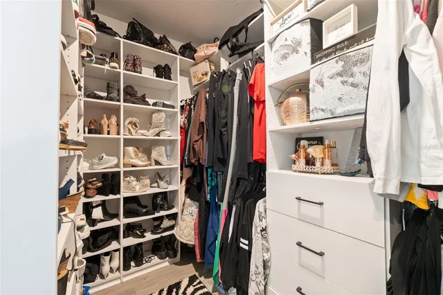 a view of walk in closet with clothes and shoes