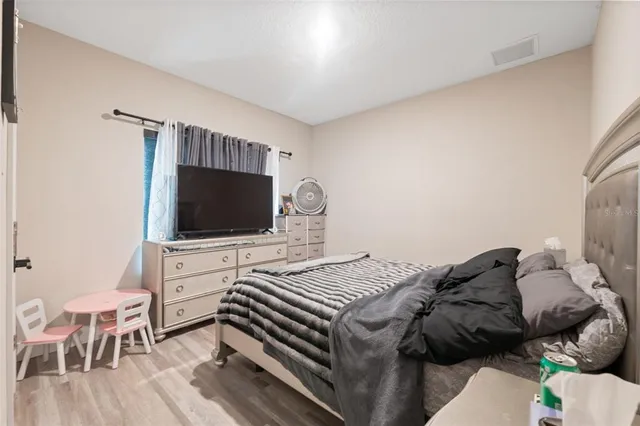 a bedroom with a bed and a flat screen tv