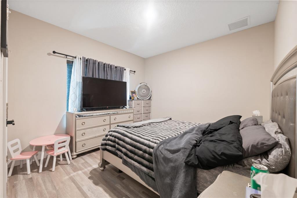 13073 Jaywalk Road Weeki Wachee, FL 34614 - Photo 15 of 44 a bedroom with a bed and a flat screen tv