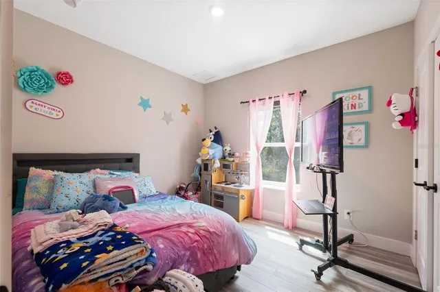 a bedroom with bed and wooden floor