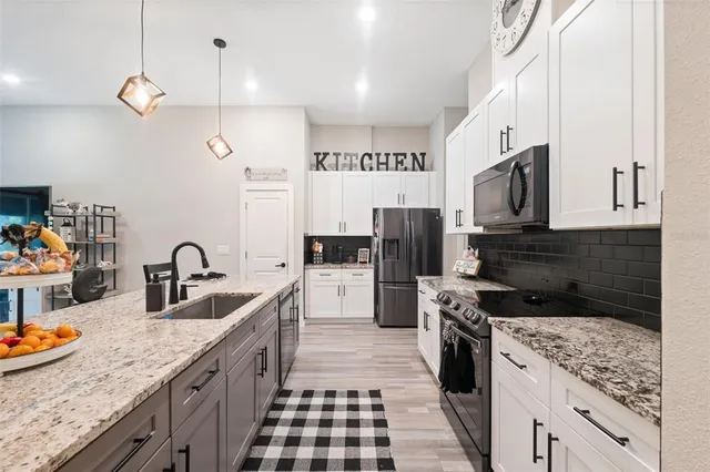 a kitchen with stainless steel appliances kitchen island granite countertop a stove and a sink