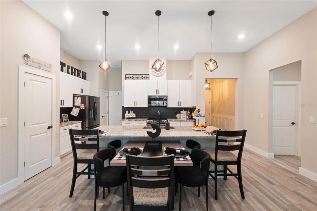 13073 Jaywalk Road Weeki Wachee, FL 34614 - Photo 36 of 44 a kitchen with stainless steel appliances a dining table chairs and wooden floor
