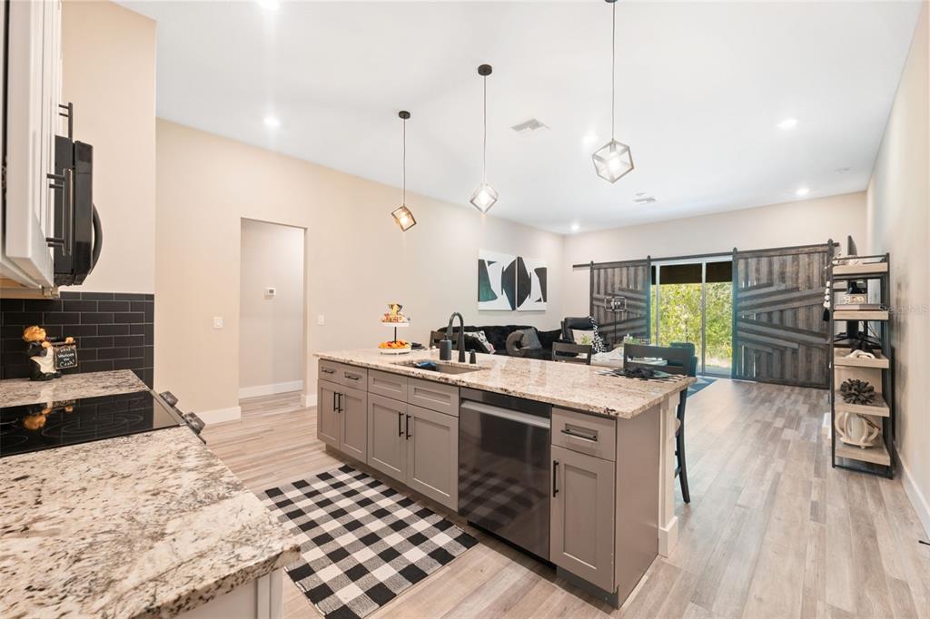 13073 Jaywalk Road Weeki Wachee, FL 34614 - Photo 38 of 44 a kitchen with stainless steel appliances kitchen island granite countertop a stove and a sink