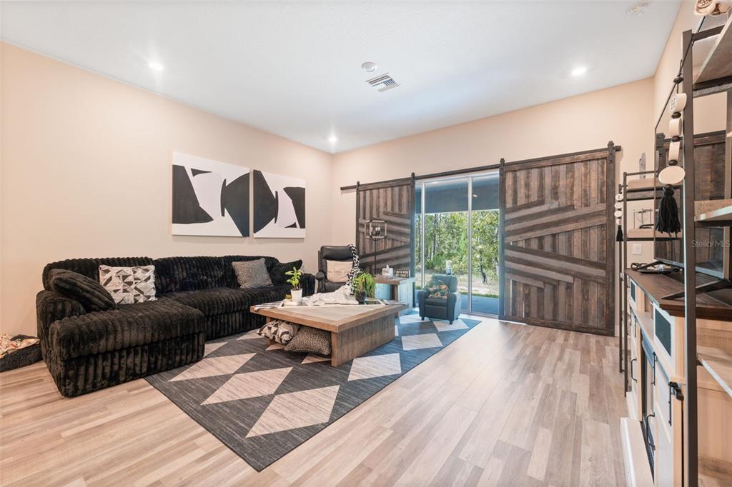 13073 Jaywalk Road Weeki Wachee, FL 34614 - Photo 39 of 44 a living room with furniture a rug and a painting on the wall