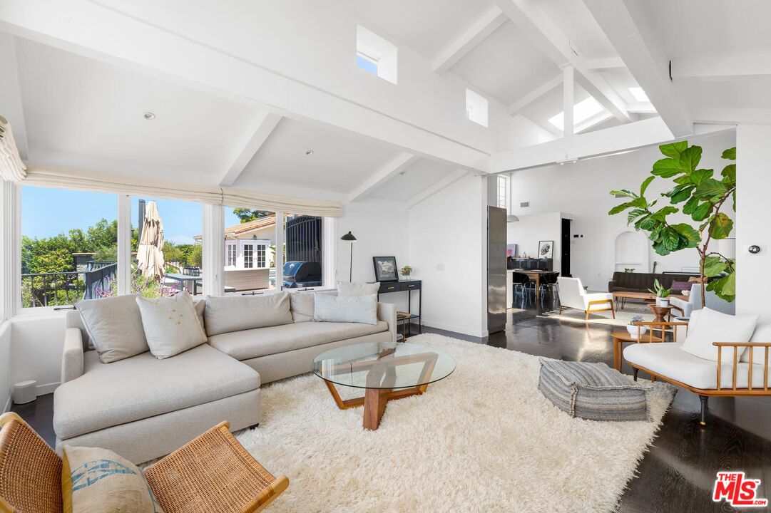 8663 Edwin Drive Los Angeles, CA 90046 - Photo 3 of 11 a living room with furniture and a dining table with kitchen view