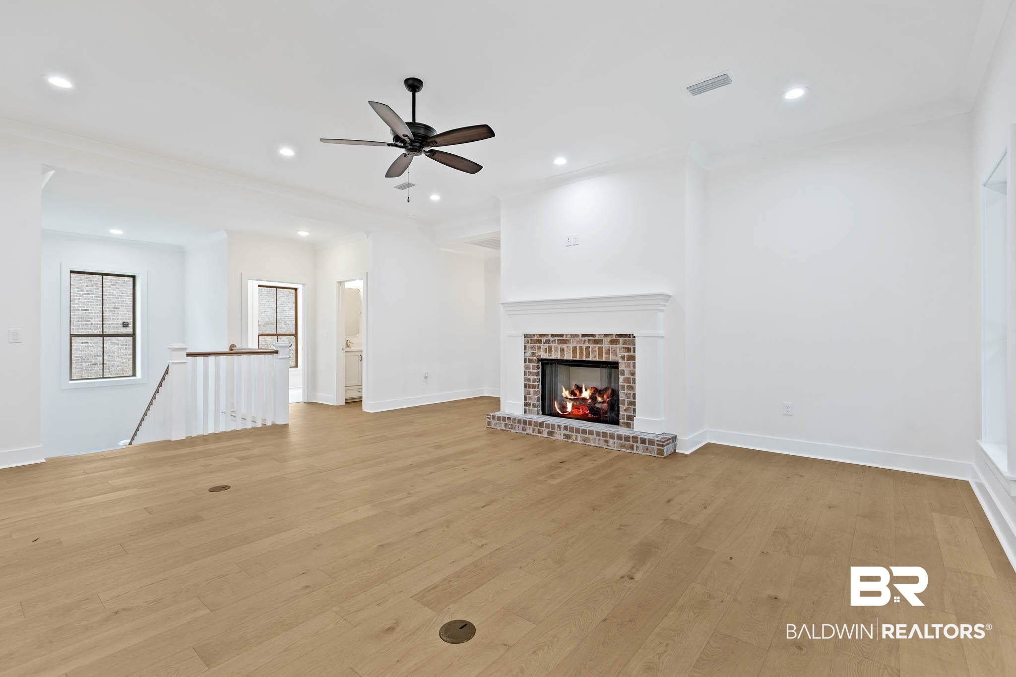 6656 Garrison Drive Daphne, AL 36527 - Photo 23 of 57 Unfurnished living room with light wood finished floors, a fireplace, crown molding, ceiling fan, and recessed lighting