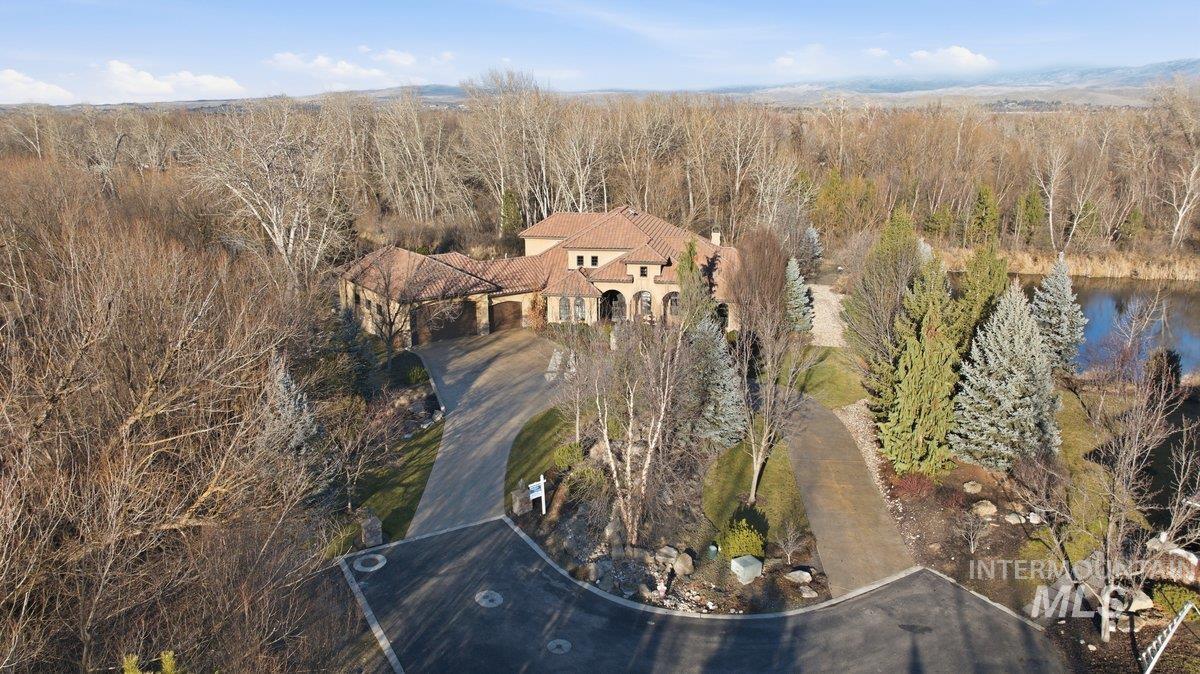 Aerial view of property and surrounding area featuring a large body of water and a heavily wooded area