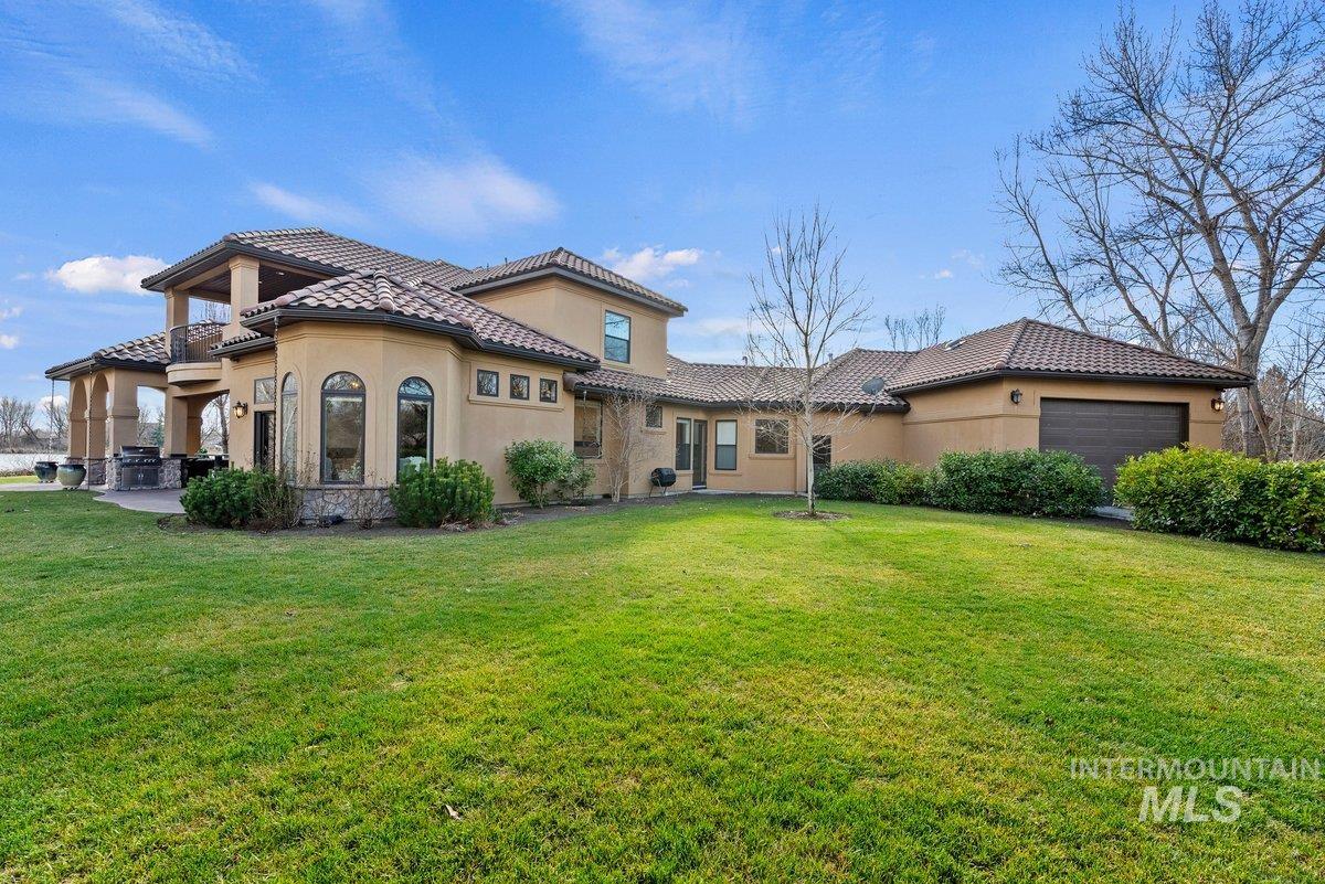 448 East Riversedge Lane Eagle, ID 83616 - Photo 42 of 50 View of front facade featuring stucco siding, a front yard, a garage, and a tiled roof
