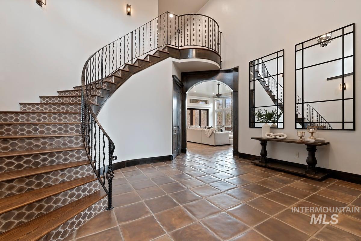 448 East Riversedge Lane Eagle, ID 83616 - Photo 7 of 50 Entryway featuring stairway, a high ceiling, dark tile patterned flooring, and arched walkways
