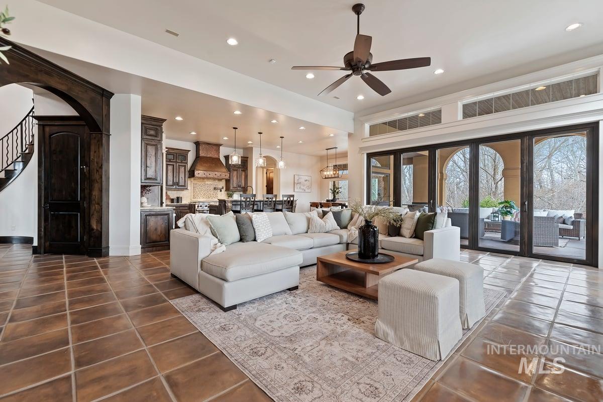 448 East Riversedge Lane Eagle, ID 83616 - Photo 9 of 50 Living area featuring arched walkways, a ceiling fan, stairs, recessed lighting, and dark tile patterned floors