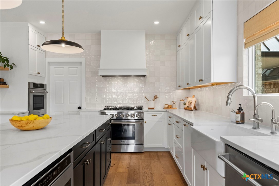 1130 Stoney Ridge Road Bulverde, TX 78163 - Photo 12 of 42 a kitchen with stainless steel appliances granite countertop a sink a stove and a wooden floors