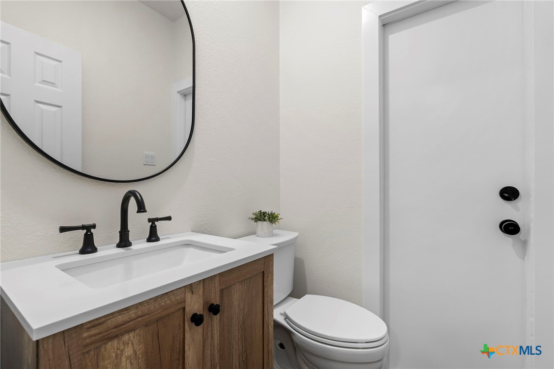 1130 Stoney Ridge Road Bulverde, TX 78163 - Photo 15 of 42 a bathroom with a sink a toilet and mirror