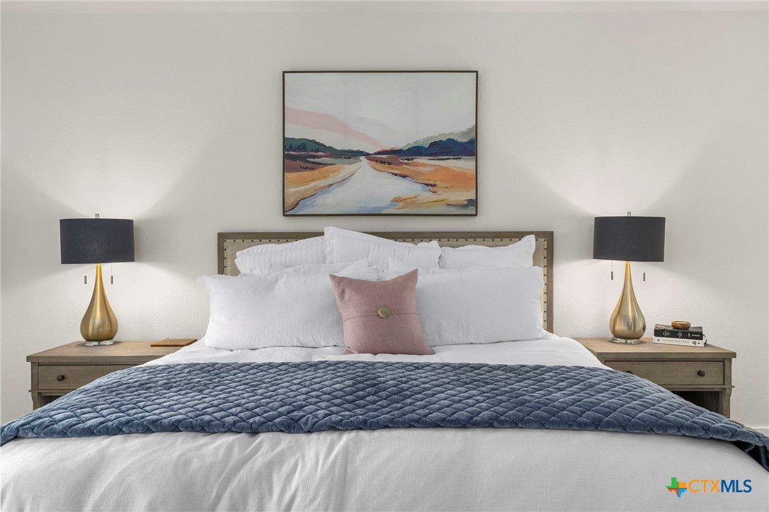 1130 Stoney Ridge Road Bulverde, TX 78163 - Photo 20 of 42 a bedroom with a bed and painting on the wall