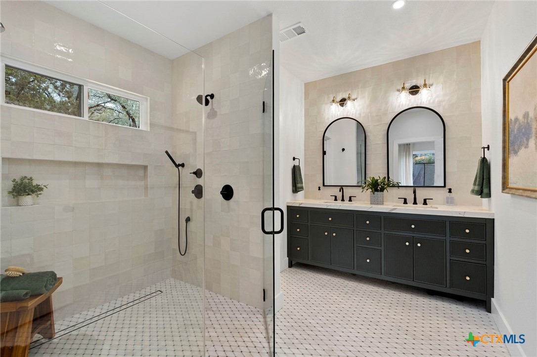 1130 Stoney Ridge Road Bulverde, TX 78163 - Photo 23 of 42 a spacious bathroom with a double vanity sink a mirror and a shower