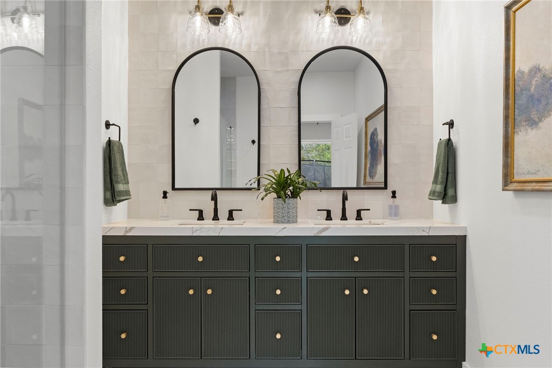1130 Stoney Ridge Road Bulverde, TX 78163 - Photo 24 of 42 a bathroom with a double vanity sink and mirror