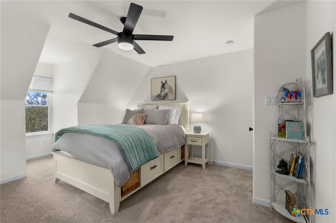 1130 Stoney Ridge Road Bulverde, TX 78163 - Photo 26 of 42 a bedroom with a bed and a chandelier