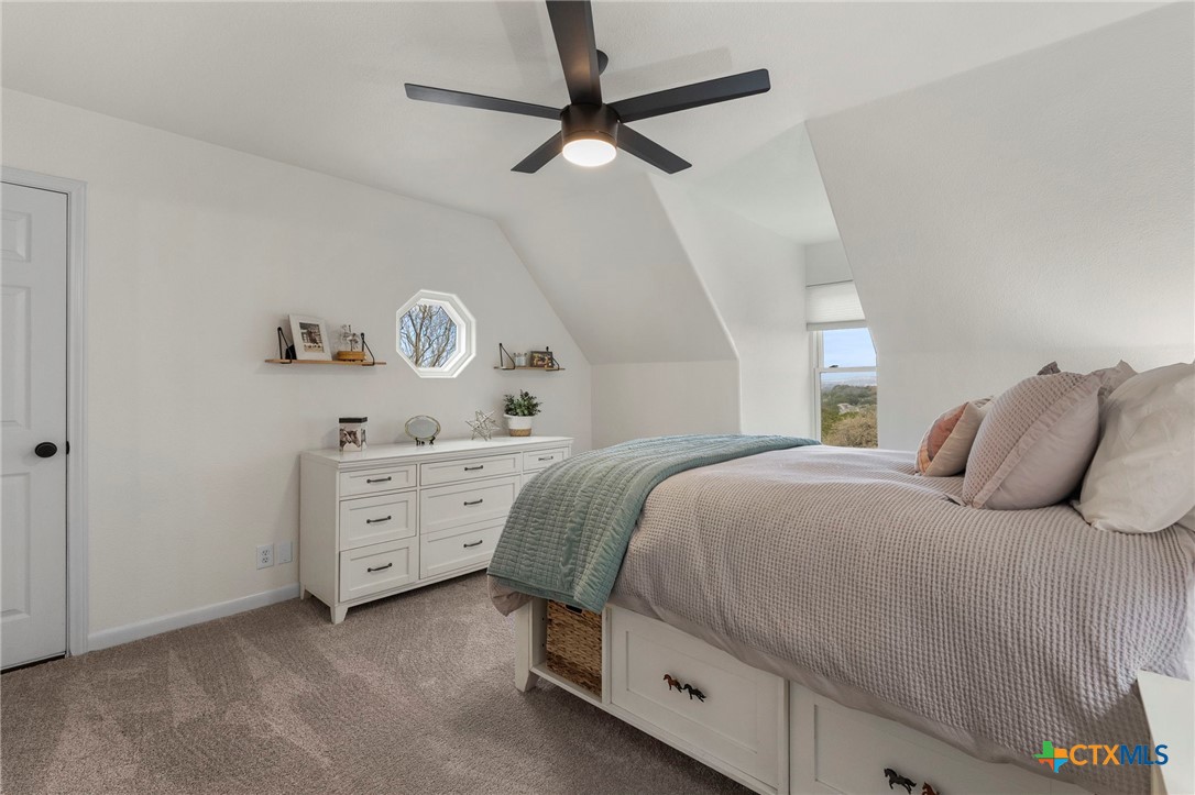 1130 Stoney Ridge Road Bulverde, TX 78163 - Photo 27 of 42 a bedroom with a bed and a chandelier