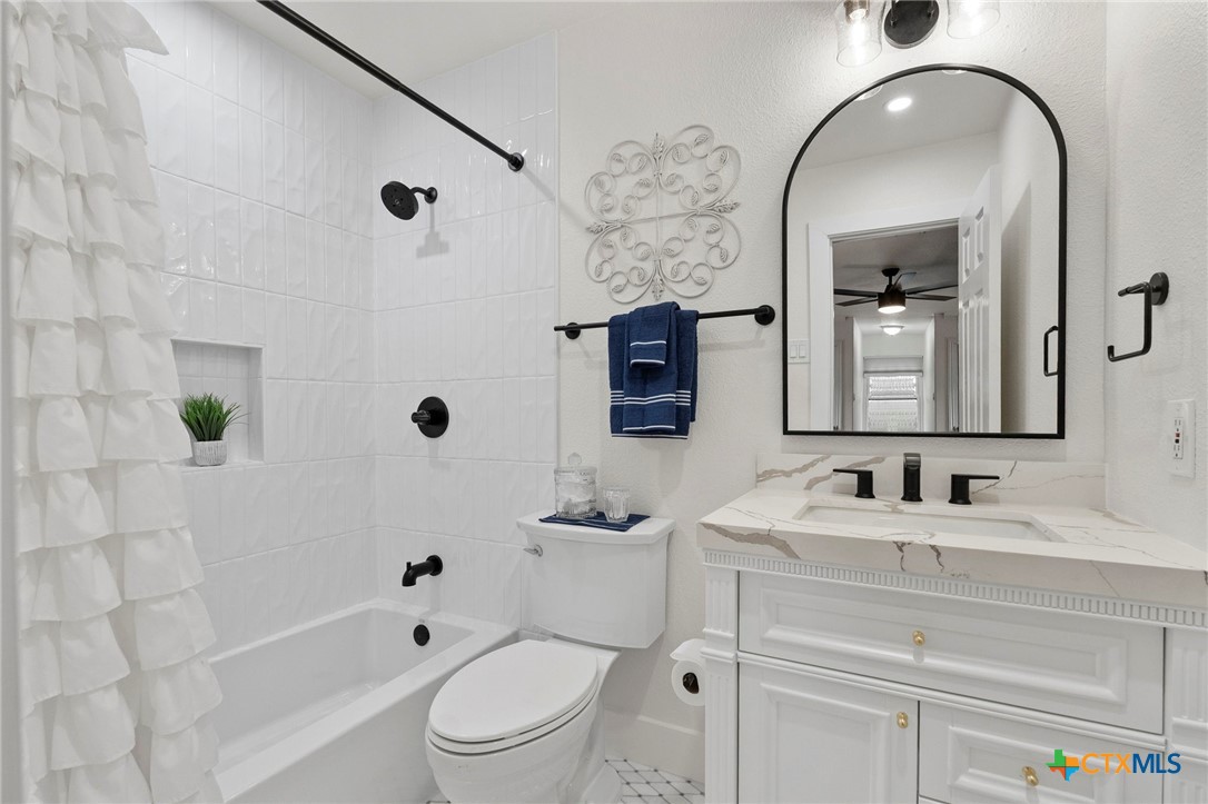 1130 Stoney Ridge Road Bulverde, TX 78163 - Photo 29 of 42 a bathroom with a toilet a sink a tub and mirror