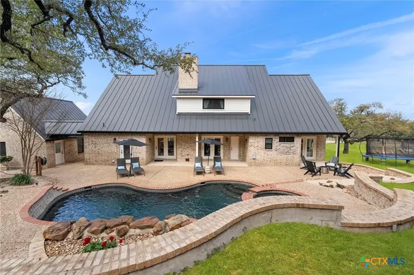 a view of a house with swimming pool and sitting area