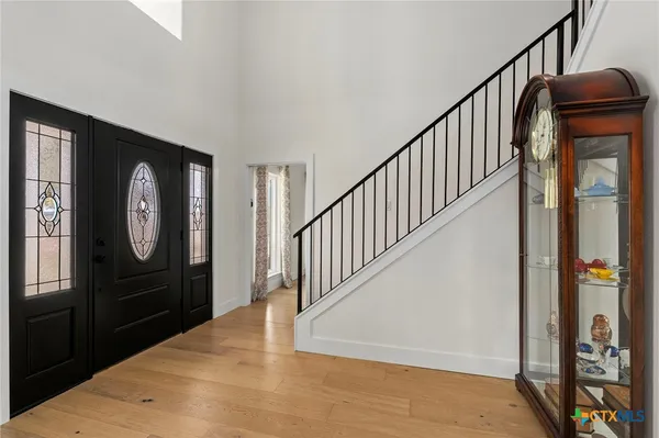 a view of a hallway with wooden floor and staircase