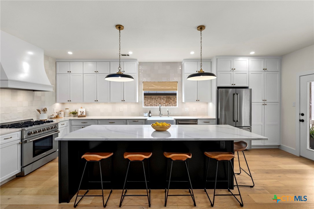 1130 Stoney Ridge Road Bulverde, TX 78163 - Photo 9 of 42 a kitchen with stainless steel appliances a dining table chairs stove and refrigerator