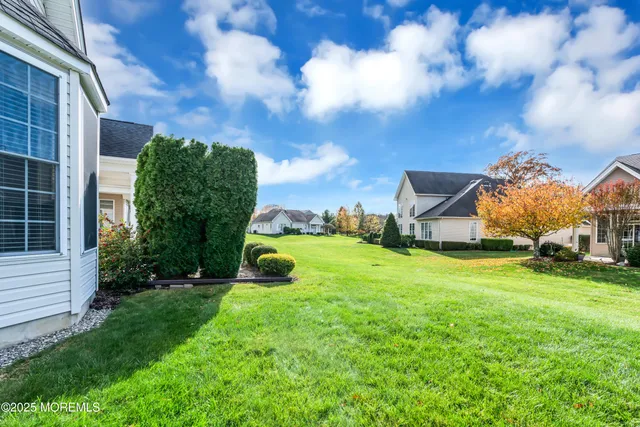 a living room with stainless steel appliances granite countertop furniture a rug kitchen view and a large window