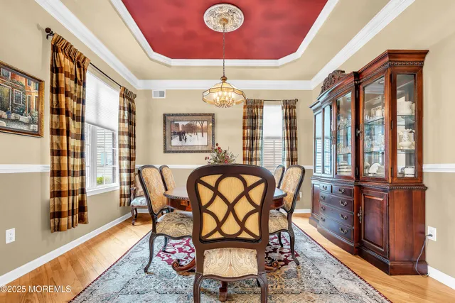 a kitchen with stainless steel appliances kitchen island granite countertop a refrigerator a stove top oven a sink dishwasher and white cabinets with wooden floor