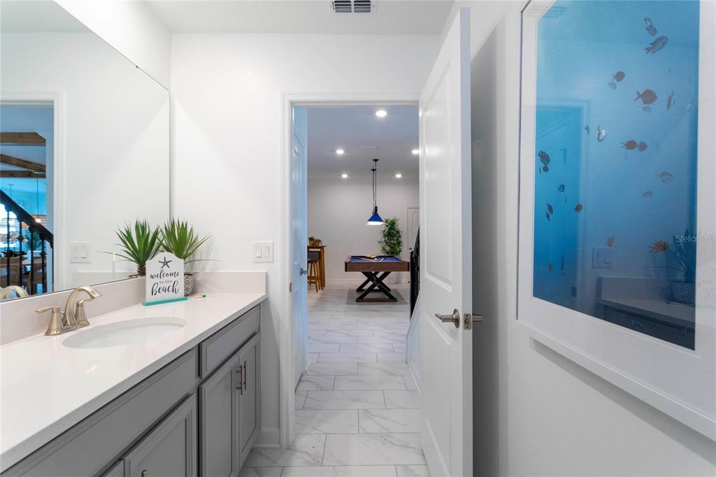 445 Strand Drive Melbourne Beach, FL 32951 - Photo 11 of 99 a bathroom with a sink a potted plant and a glass door