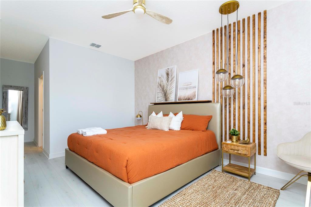 445 Strand Drive Melbourne Beach, FL 32951 - Photo 46 of 99 a bedroom with a bed and a chandelier