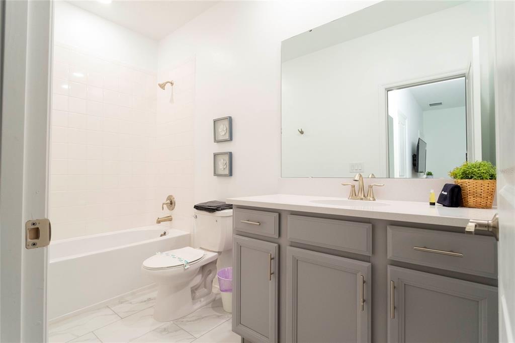 445 Strand Drive Melbourne Beach, FL 32951 - Photo 66 of 99 a bathroom with a toilet a sink a tub and mirror