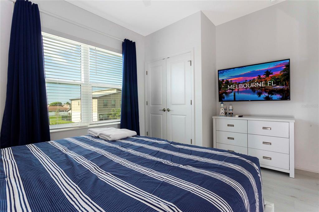 445 Strand Drive Melbourne Beach, FL 32951 - Photo 77 of 99 a bedroom with a bed and a flat screen tv