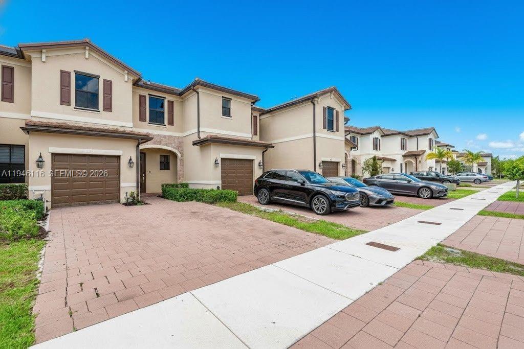3326 West 112th Street Hialeah, FL 33018 - Photo 2 of 37 a front view of a house with a yard and garage