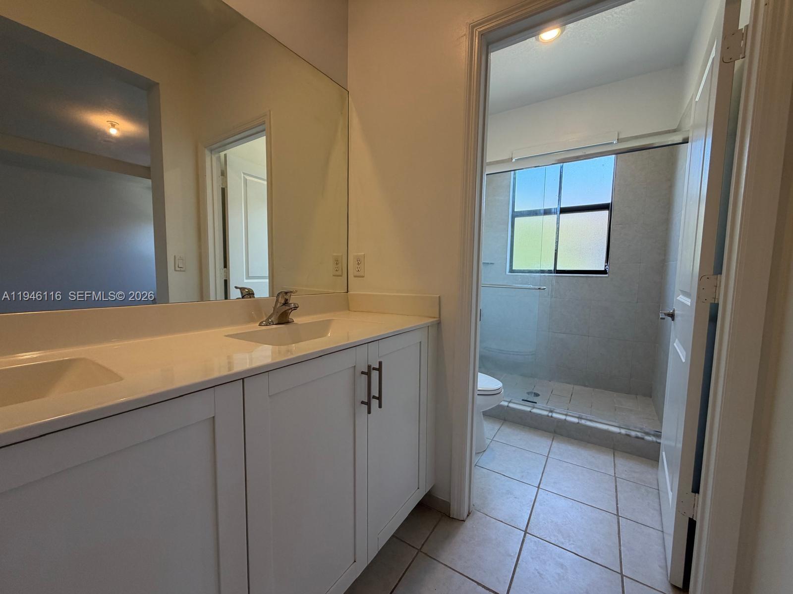 3326 West 112th Street Hialeah, FL 33018 - Photo 23 of 37 a bathroom with a double vanity sink and a mirror