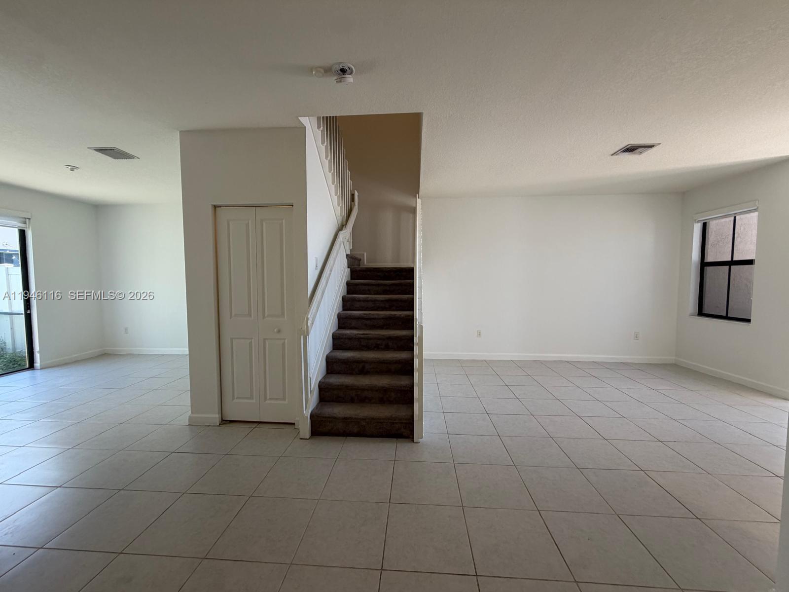 3326 West 112th Street Hialeah, FL 33018 - Photo 5 of 37 a view of a livingroom with an empty space and stairs
