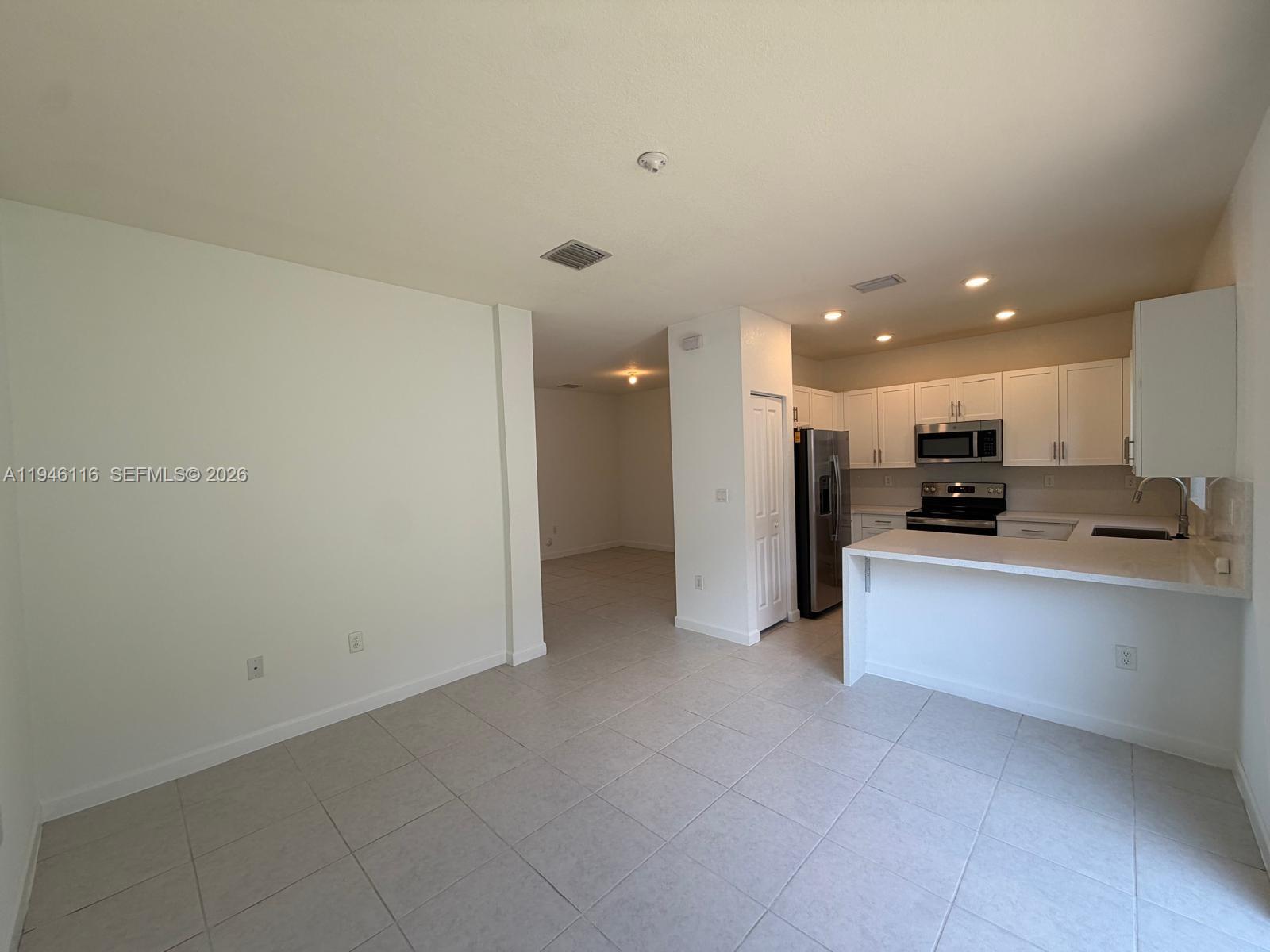3326 West 112th Street Hialeah, FL 33018 - Photo 7 of 37 a view of a kitchen with kitchen island and stainless steel appliances