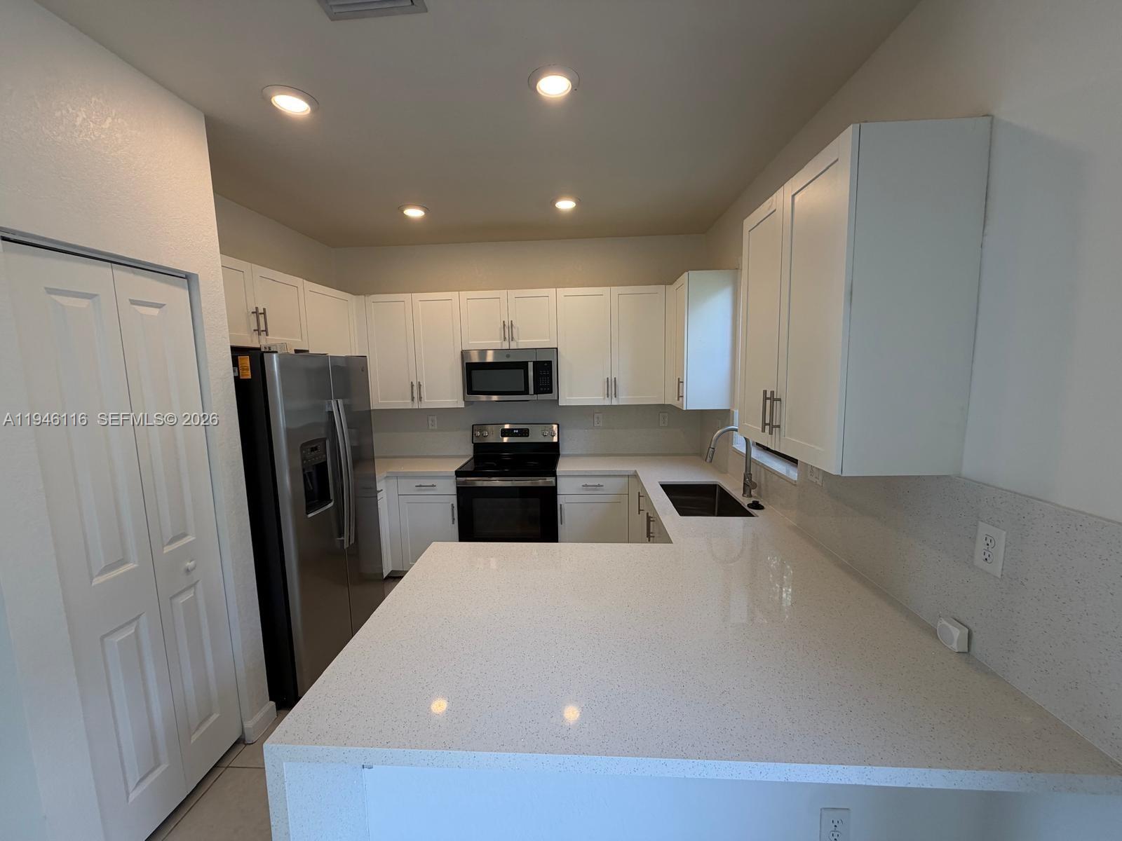 3326 West 112th Street Hialeah, FL 33018 - Photo 8 of 37 a kitchen with stainless steel appliances a refrigerator and a stove