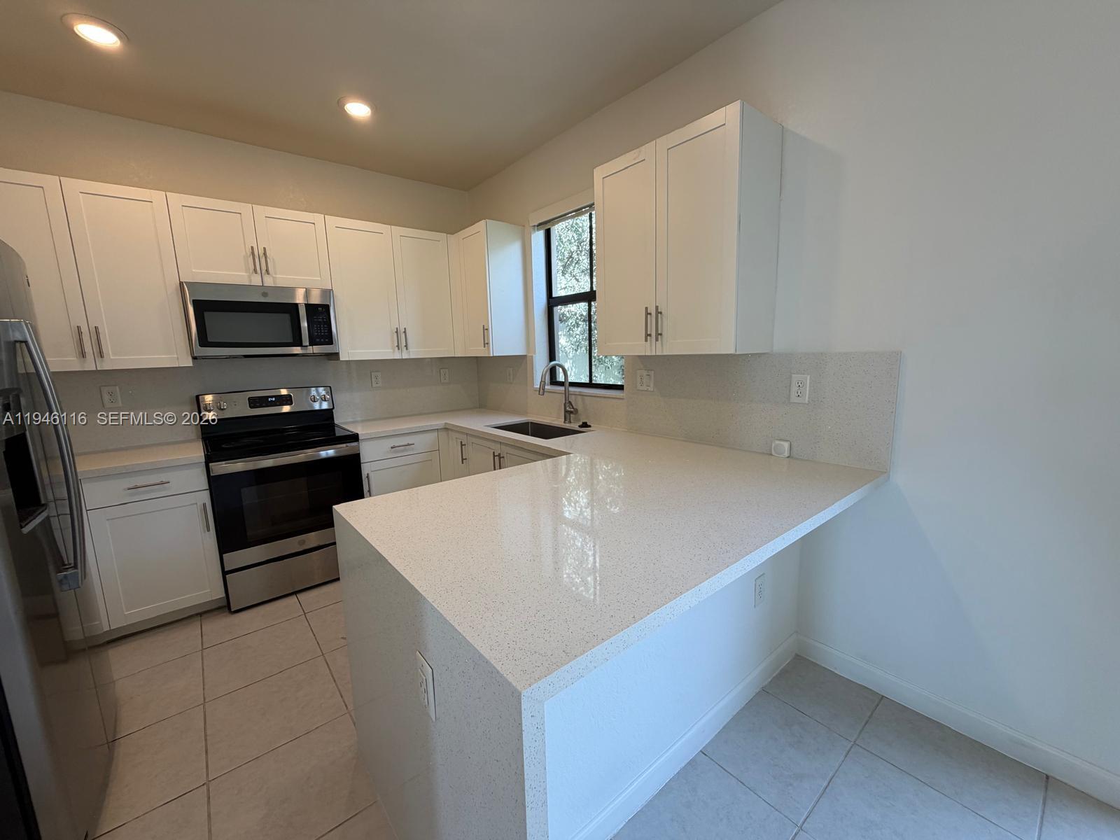 3326 West 112th Street Hialeah, FL 33018 - Photo 9 of 37 a kitchen that has a sink and a stove in it