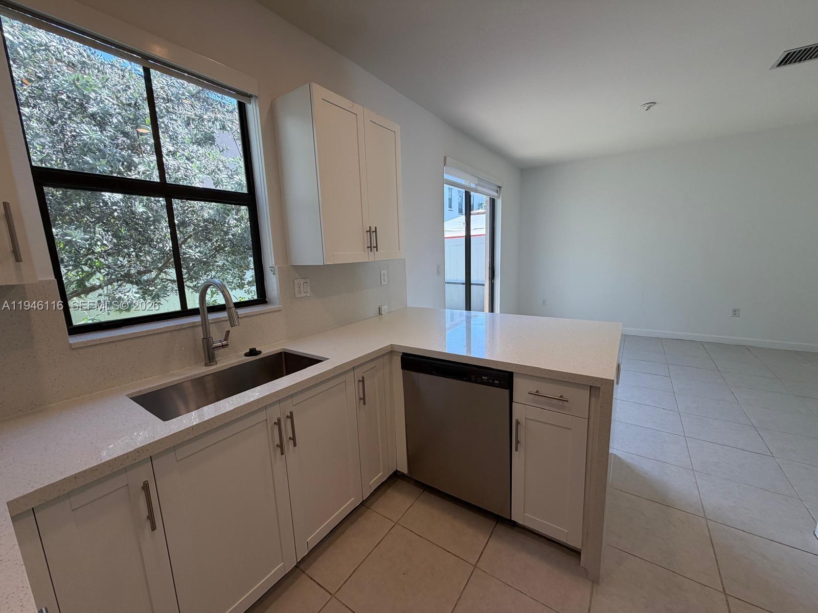 3326 West 112th Street Hialeah, FL 33018 - Photo 10 of 37 a kitchen with a sink window and cabinets