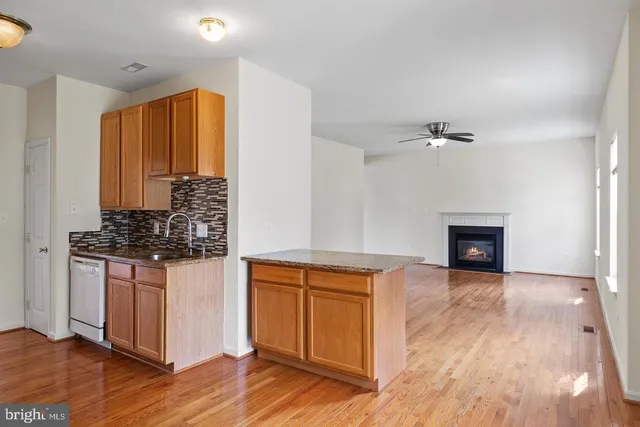 a kitchen with stainless steel appliances granite countertop a stove and a wooden floors