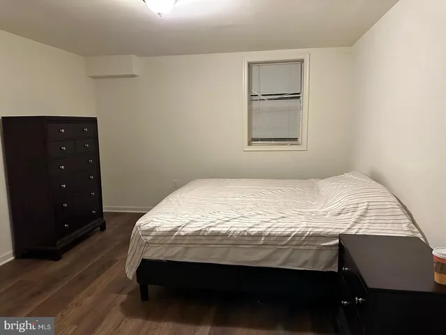 a bedroom with a bed and a lamp on dresser