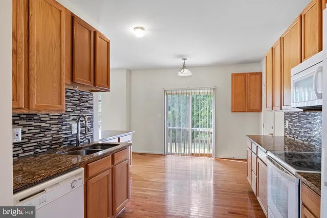 a kitchen with stainless steel appliances granite countertop a sink stove and cabinets