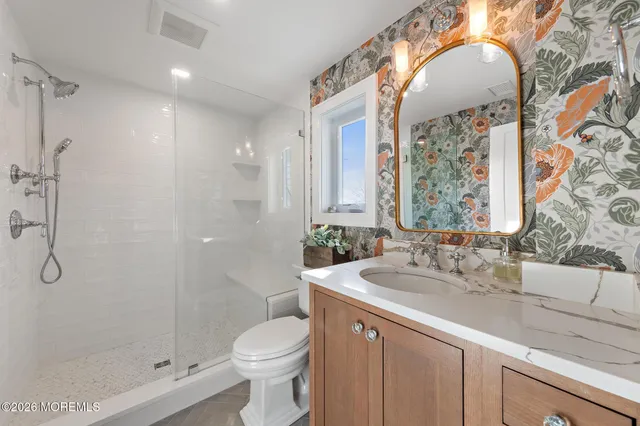 a bathroom with a double vanity sink toilet and shower